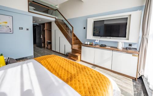 a bedroom with a large bed and a television at Kunming Xingyao Hotel in Kunming