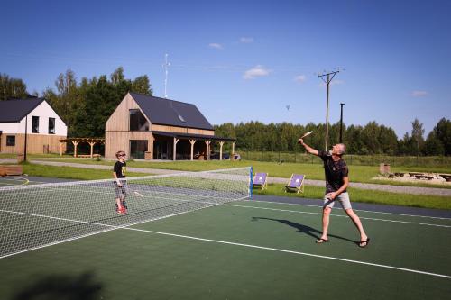 two people playing tennis on a tennis court at Moje Miejsce Kazimierz in Kazimierz Dolny