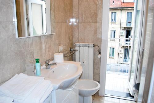 een badkamer met een wastafel, een toilet en een raam bij Milan Shopping Street in Milaan