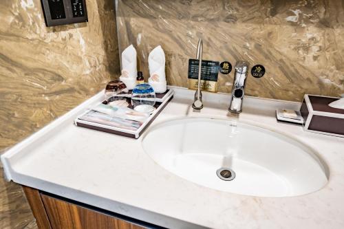 a white sink in a bathroom with a counter top at Kunming Xingyao Hotel in Kunming