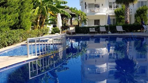 a swimming pool in front of a house at Belka Golf Residence Exclusive Apt Poolside in Belek