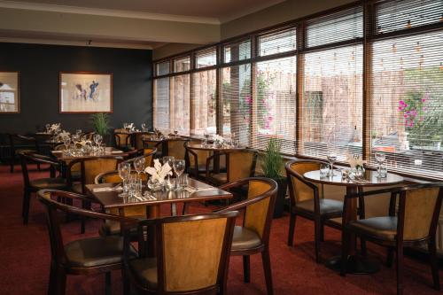 un restaurante con mesas, sillas y ventanas en Downhill Inn, en Ballina