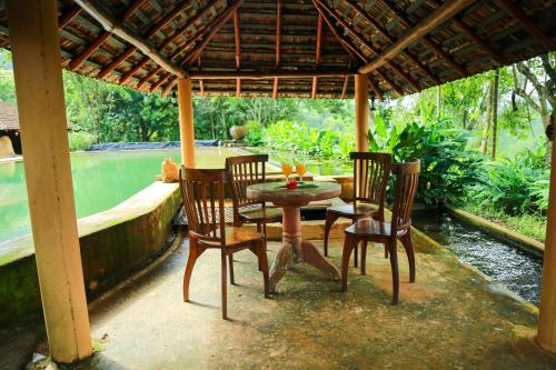 a table and chairs under a pavilion on a patio at Rainforest Edge in Kalawana