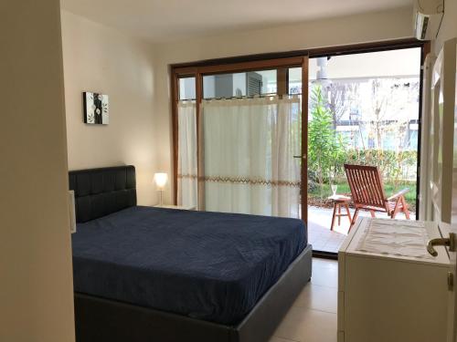 a bedroom with a bed and a door to a patio at Costa Azzurra Apartment in Grado