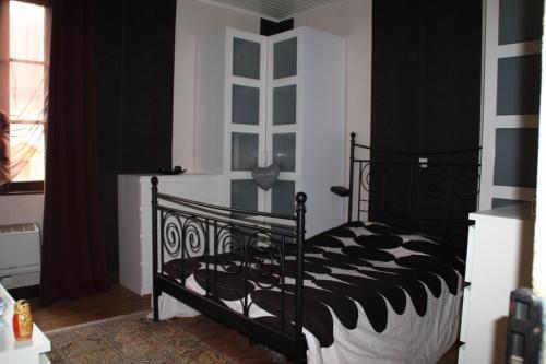 a bedroom with a black and white bed and a window at Maison classée 50m océan de 2 à 12 personnes in Mimizan