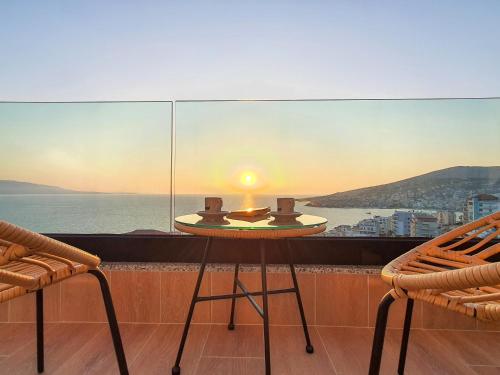 a table and chairs on a balcony with a view of the ocean at Meraviglia Boutique Hotel in Sarandë
