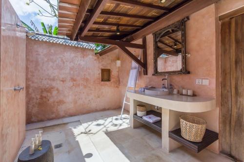 a bathroom with a sink and a mirror at Bali Villa Home in Seminyak