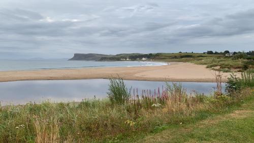 a beach with a body of water next to a beach at Seaside Apartment - 2 storey 2 bedrooms in Ballycastle