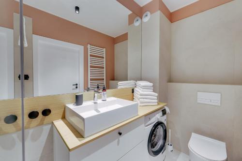 a bathroom with a white sink and a toilet at Apartament OAK TREE SurfingBird Dźwirzyno in Dźwirzyno