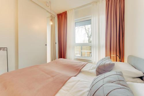 a bedroom with a bed and a window at Apartament OAK TREE SurfingBird Dźwirzyno in Dźwirzyno