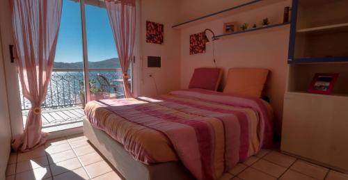 a bedroom with a bed and a large window at Studio 2- lake view in Oggebbio