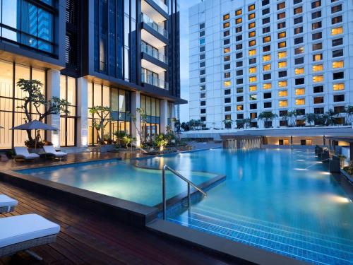 a large swimming pool in the middle of a building at Mangkuluhur ARTOTEL SUITES in Jakarta