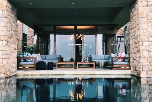 a living room with couches and a pool of water at Cloud 9 Luxury Eco Villa in Sedgefield