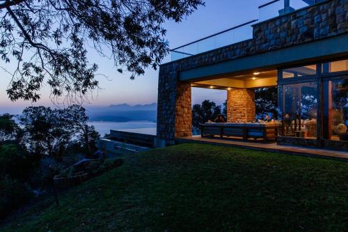 a house with a view of the ocean at dusk at Cloud 9 Luxury Eco Villa in Sedgefield