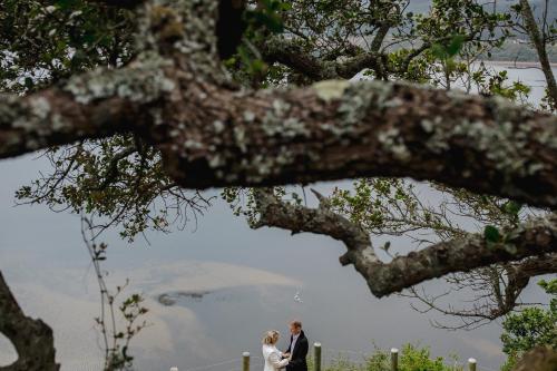 a bride and groom standing under a tree at Cloud 9 Luxury Eco Villa in Sedgefield