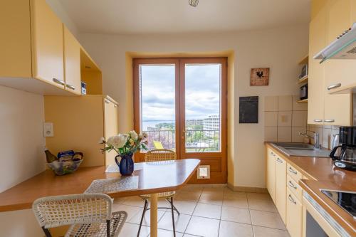 une cuisine avec une table et des chaises et une fenêtre dans l'établissement Appartement 2p au Belvédère, à Thonon-les-Bains