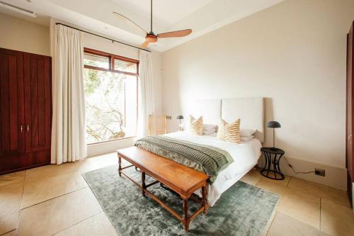 a white bedroom with a bed and a window at Cloud 9 Luxury Eco Villa in Sedgefield