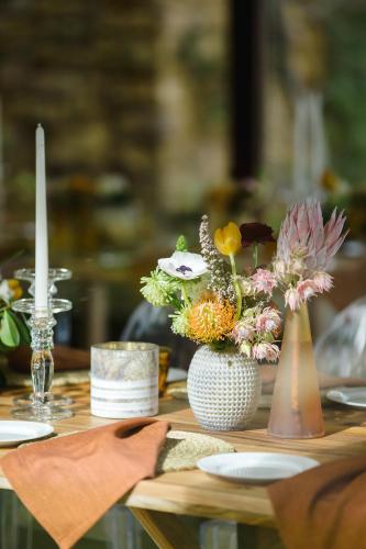 a table with flowers in vases on top of it at Cloud 9 Luxury Eco Villa in Sedgefield