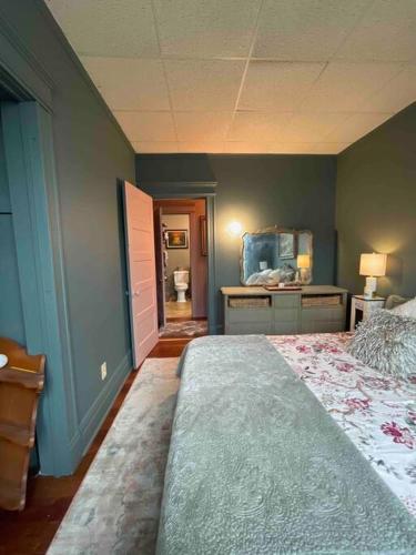 a bedroom with a large bed and a bathroom at Redefined Alchemy - The Studio in Little Falls