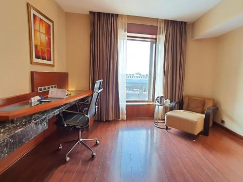 a hotel room with a desk and chairs and a window at Radisson Blu Plaza Delhi Airport in New Delhi