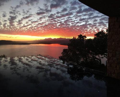 a sunset over a body of water with the sky at Cloud 9 Luxury Eco Villa in Sedgefield
