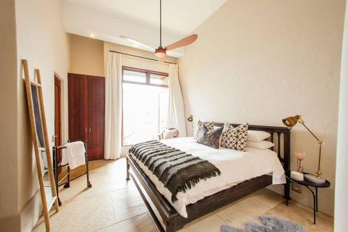 a bedroom with a bed and a large window at Cloud 9 Luxury Eco Villa in Sedgefield