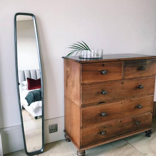 a dresser with a mirror on top of it at Cloud 9 Luxury Eco Villa in Sedgefield
