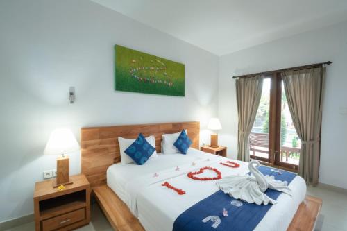 een slaapkamer met een bed met een zwanendecoratie bij Green Papaya House in Ubud