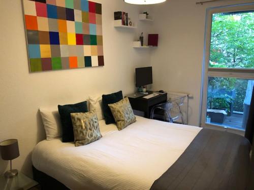 a bedroom with a bed with a desk and a colorful painting at Best Apartment in the Center of Berlin with Big Terrace in Berlin