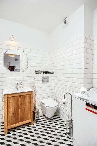 a white bathroom with a sink and a toilet at Jutrzenka in Wrocław