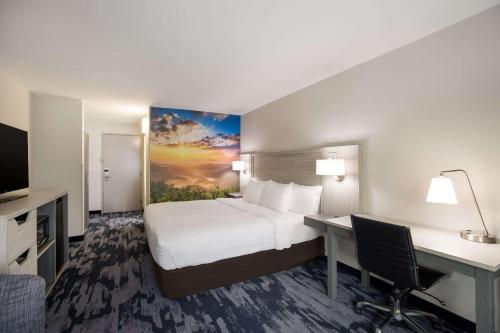 a hotel room with a bed and a desk at Clarion Pointe Sylva near Cherokee Area in Dillsboro