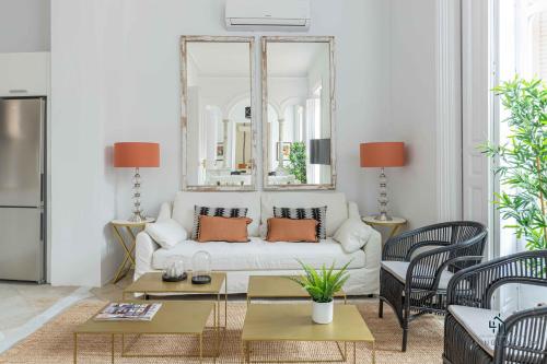 sala de estar con sofá blanco y espejo en Living4Malaga Stylish Monroy, en Málaga