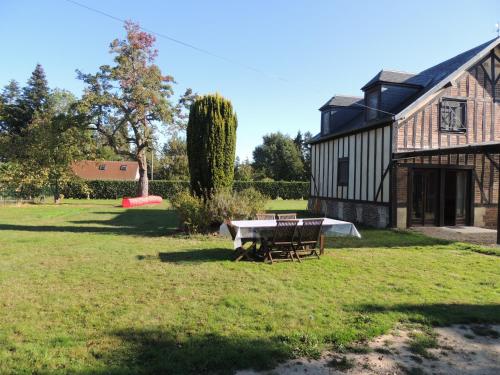 a picnic table in front of a barn at La Chaumière du bout du chemin - 7p - Ch RDC in Neuville-sur-Touques