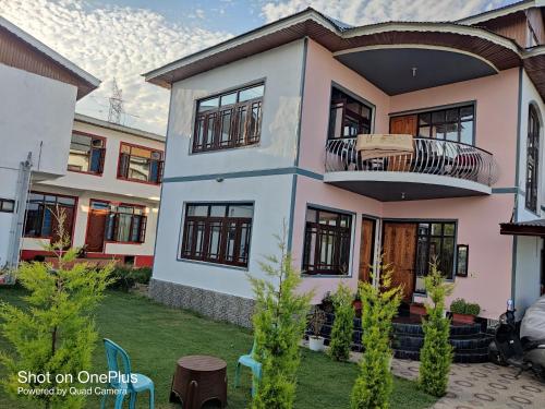 a house with a balcony in a yard at Kashmir Homestay in Gulmarg