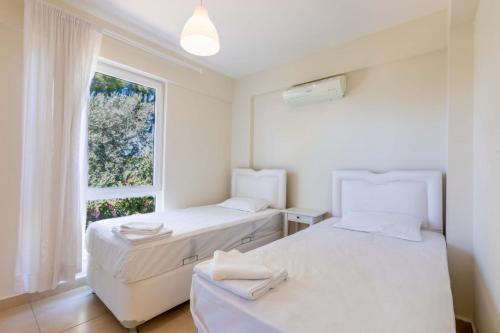 - 2 lits dans une chambre avec fenêtre dans l'établissement Peaceful Home Surrounded by Nature in Kas, à Gelemiş