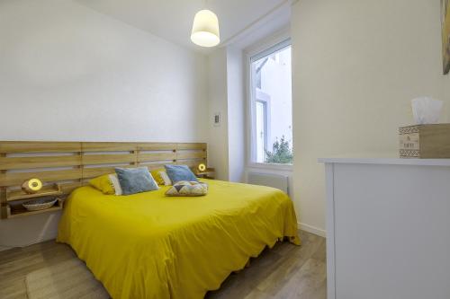 une chambre avec un lit jaune avec une fenêtre dans l'établissement Superbe F1 avec terrasse et parking privé, à Évian-les-Bains