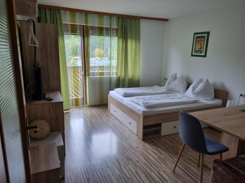 a bedroom with a bed and a desk and a window at Appartementhotel Rutar Lido in Eberndorf