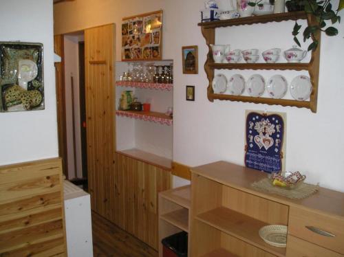 kuchnia ze stołem i półkami z naczyniami na ścianie w obiekcie Apartment Marie w mieście Jáchymov