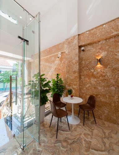 a glass room with a table and chairs at Uy Dương Hotel & Apartment - Nha Trang in Nha Trang