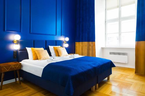 a blue bedroom with a bed with a blue wall at Glamorous Apartment in heart of Old Town in Krakow