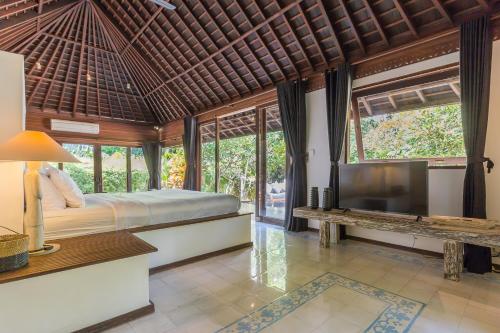 a bedroom with a large bed and a television at Bali Villa Home in Seminyak