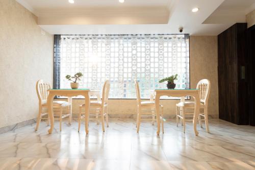 a dining room with two tables and chairs and a window at Hotel CASA Aishbagh in Lucknow
