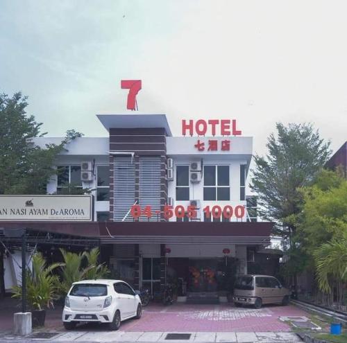 a hotel with two cars parked in front of it at 7 Hotel in Juru