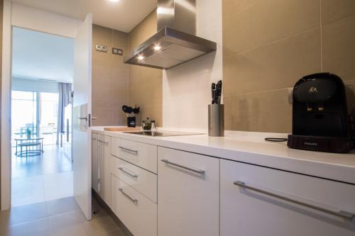 - une cuisine avec des placards blancs et un évier dans l'établissement INTEMPO SKY Apartments 034, à Benidorm