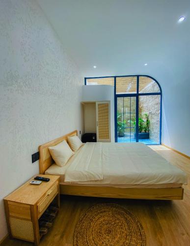 a large bed in a room with a large window at MOONLIGHT Homestay & Hotel in Pleiku