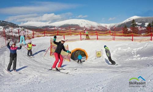 a group of people on skis in the snow at Horský hotel Žižkova bouda in Pec pod Sněžkou