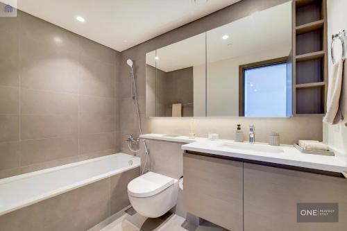 a bathroom with a toilet and a sink and a mirror at High Floor - Stunning Location - Canal View in Dubai