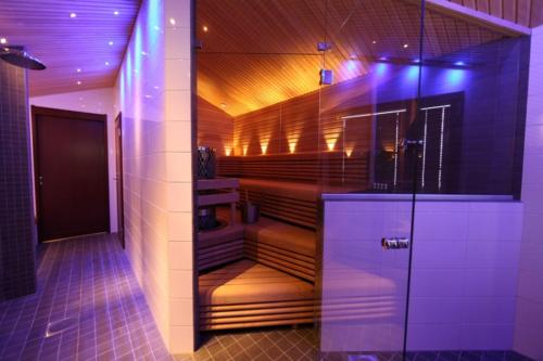 a sauna with brown seats in a room with purple lights at Levi Cirius in Kittilä