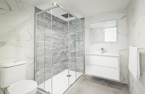 een badkamer met een douche, een toilet en een wastafel bij Villacana 2907 in Estepona