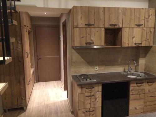 a kitchen with wooden cabinets and a sink at Two various entire apartments in New Gudauri -Redco, Near Main Gondola in Gudauri